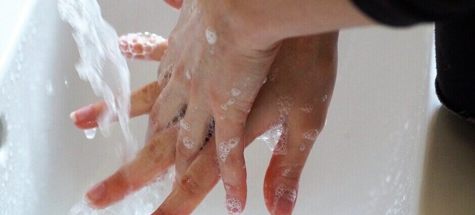 Higienização das mãos com água e sabão no momento de esfregar os espaços entre os dedos para prevenção da covid-19.