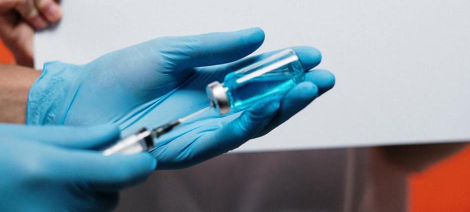Mãos segurando uma vacina em teste para o novo coronavírus.