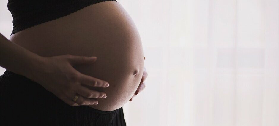 Mulher grávida com as mãos na barriga. É preciso evitar o coronavírus na gestação.